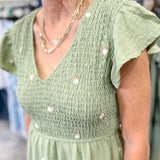 Olive green midi length dress with embroidered flower detail. Smocked top. Short sleeves.