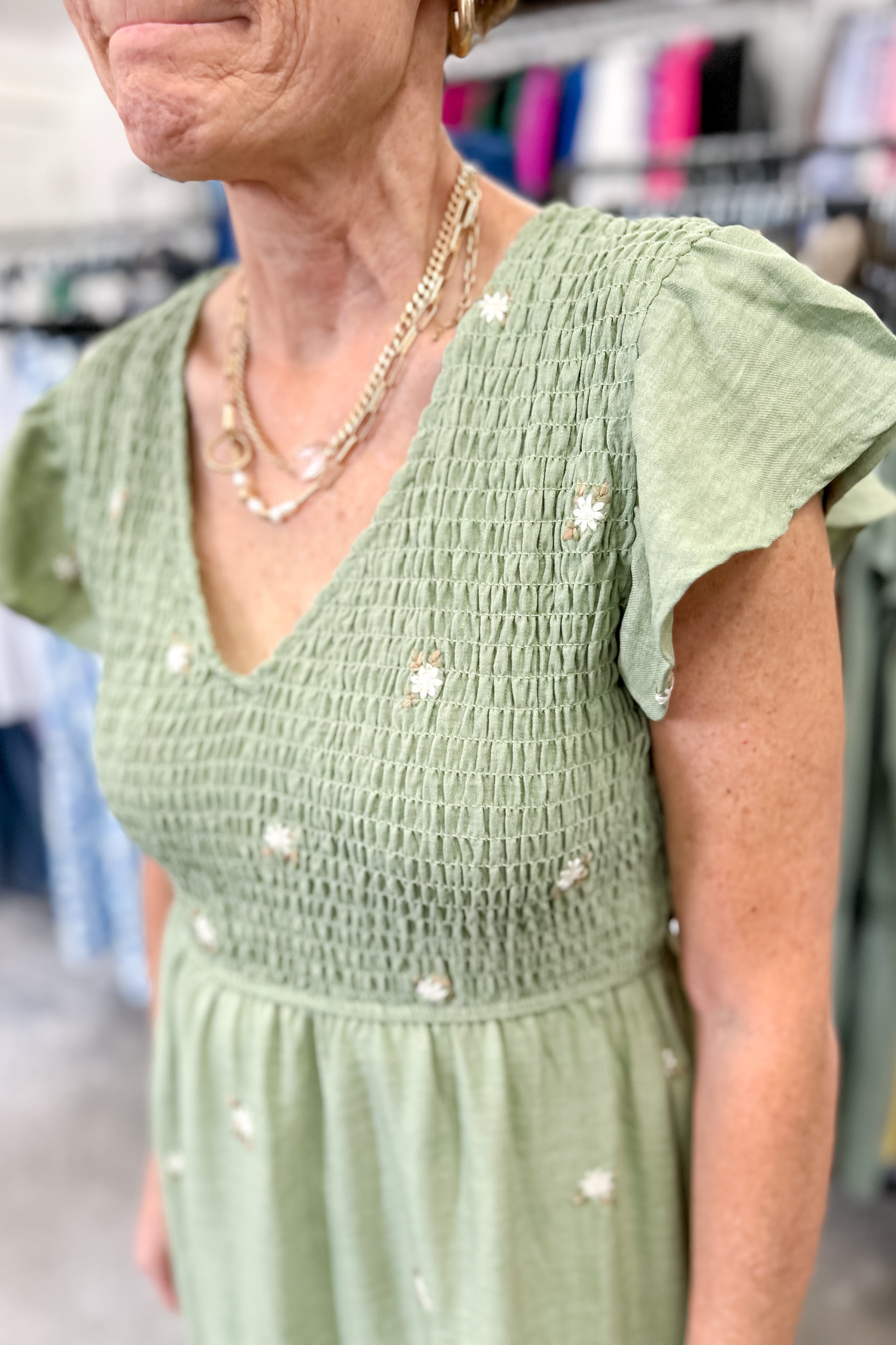 Olive green midi length dress with embroidered flower detail. Smocked top. Short sleeves.