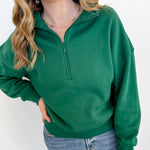 Person wearing a green pullover with a white background