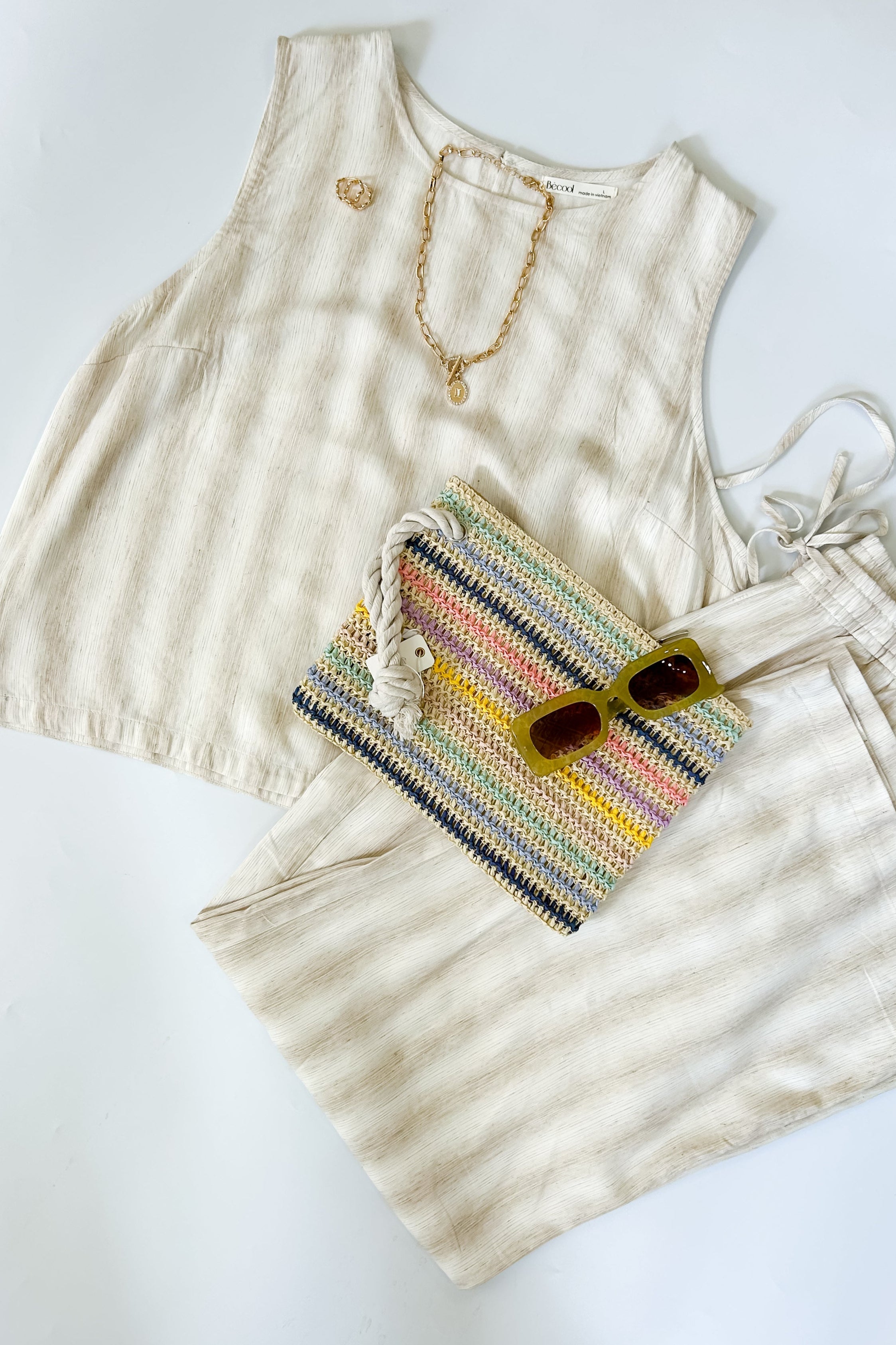 Striped tank and matching pants set. High neckline on top and regular fitting pants. Elastic waistline with tie.  White and tan in color.