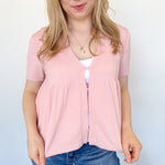 Babydoll style stop with open button up front. Short sleeve. Lightweight sweater material. Light pink in color.