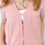 Babydoll style stop with open button up front. Short sleeve. Lightweight sweater material. Light pink in color.