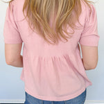 Babydoll style stop with open button up front. Short sleeve. Lightweight sweater material. Light pink in color.