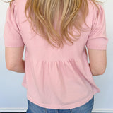 Babydoll style stop with open button up front. Short sleeve. Lightweight sweater material. Light pink in color.
