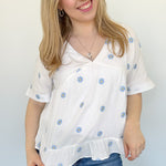 Woven top with light blue embroidered flowers. V neckline. Loose fit. Short sleeve. 