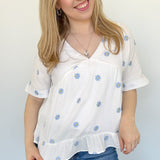 Woven top with light blue embroidered flowers. V neckline. Loose fit. Short sleeve. 