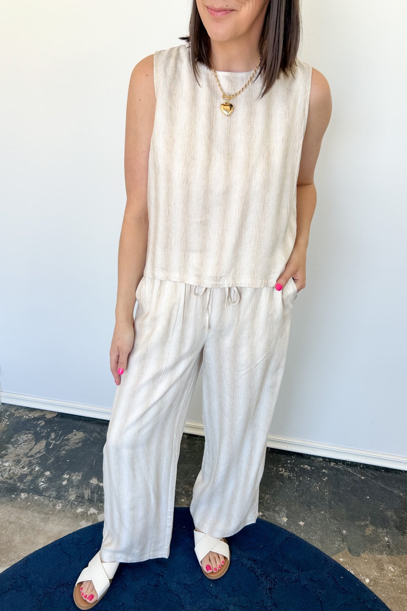 Striped tank and matching pants set. High neckline on top and regular fitting pants. Elastic waistline with tie.  White and tan in color.