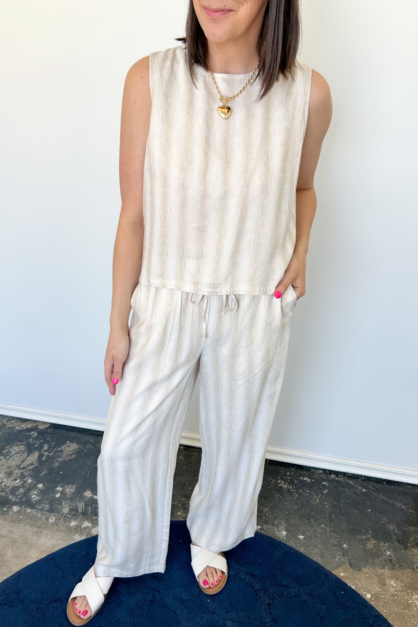 Striped tank and matching pants set. High neckline on top and regular fitting pants. Elastic waistline with tie.  White and tan in color.