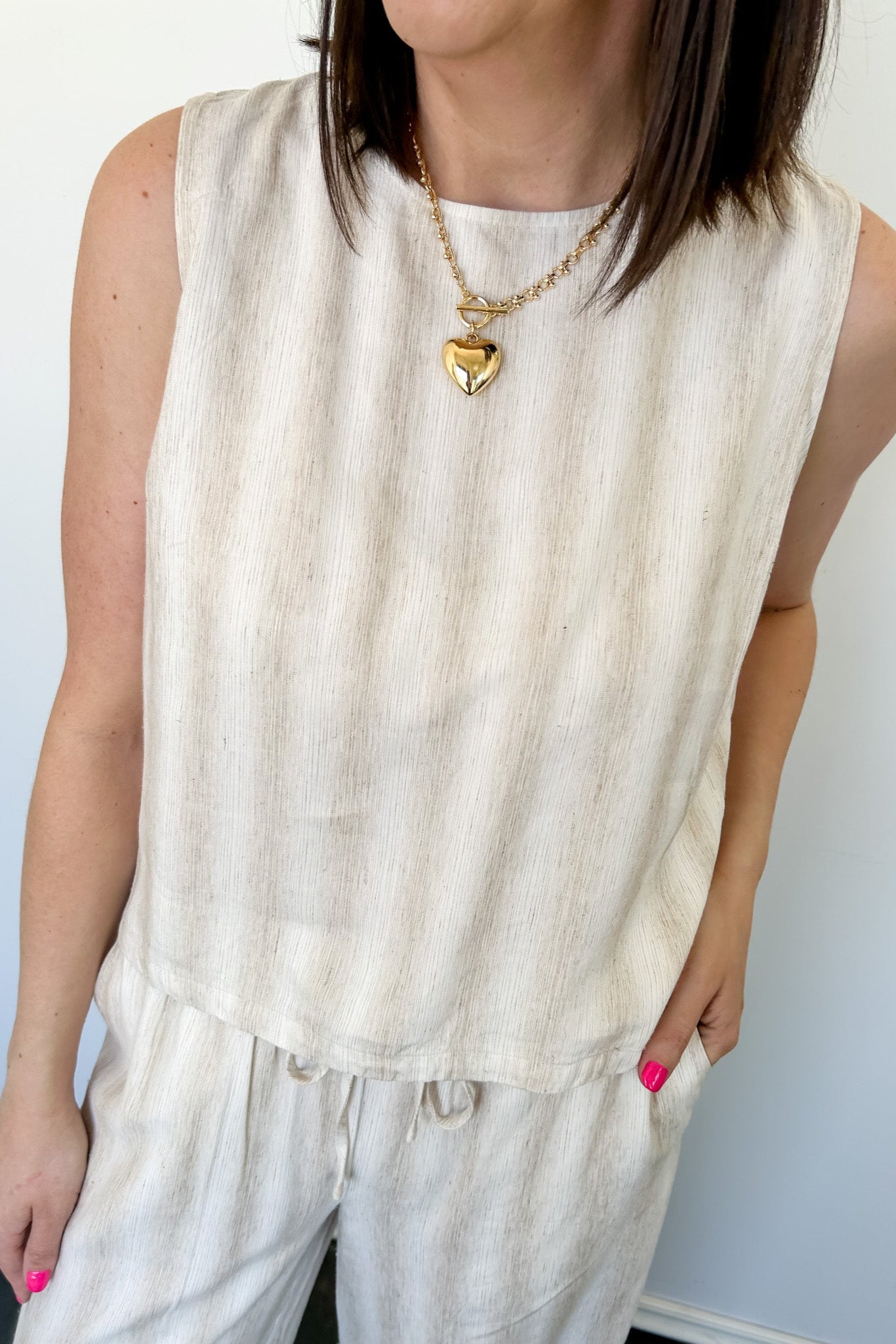 Striped tank and matching pants set. High neckline on top and regular fitting pants. Elastic waistline with tie.  White and tan in color.
