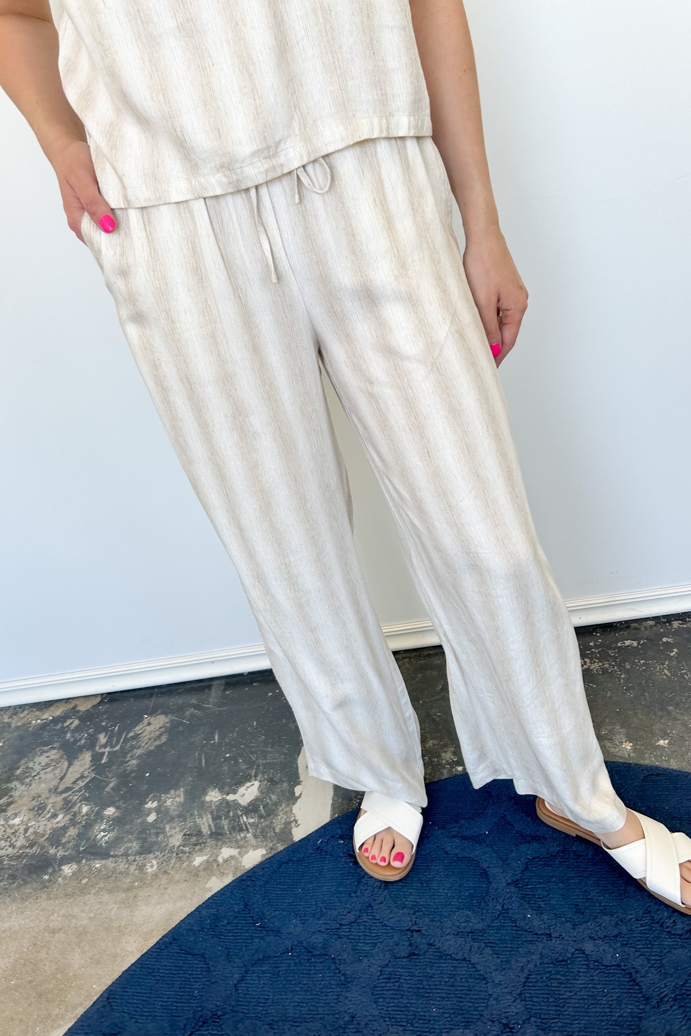 Striped tank and matching pants set. High neckline on top and regular fitting pants. Elastic waistline with tie.  White and tan in color.