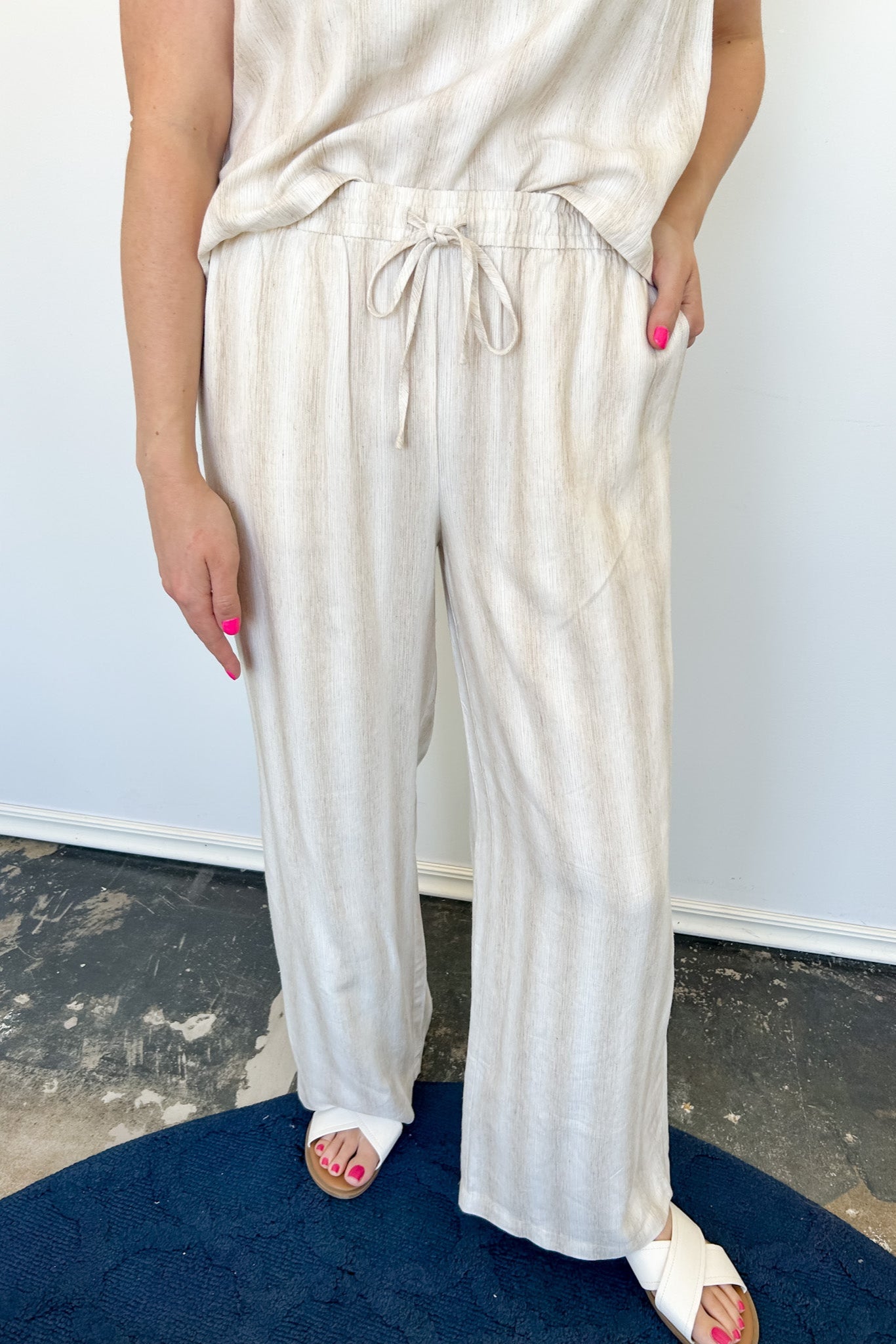 Striped tank and matching pants set. High neckline on top and regular fitting pants. Elastic waistline with tie.  White and tan in color.
