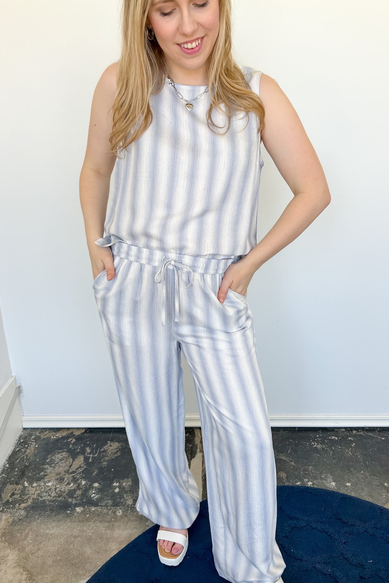 Striped tank and matching pants set. High neckline on top and regular fitting pants. Elastic waistline with tie.  White and blue in color.