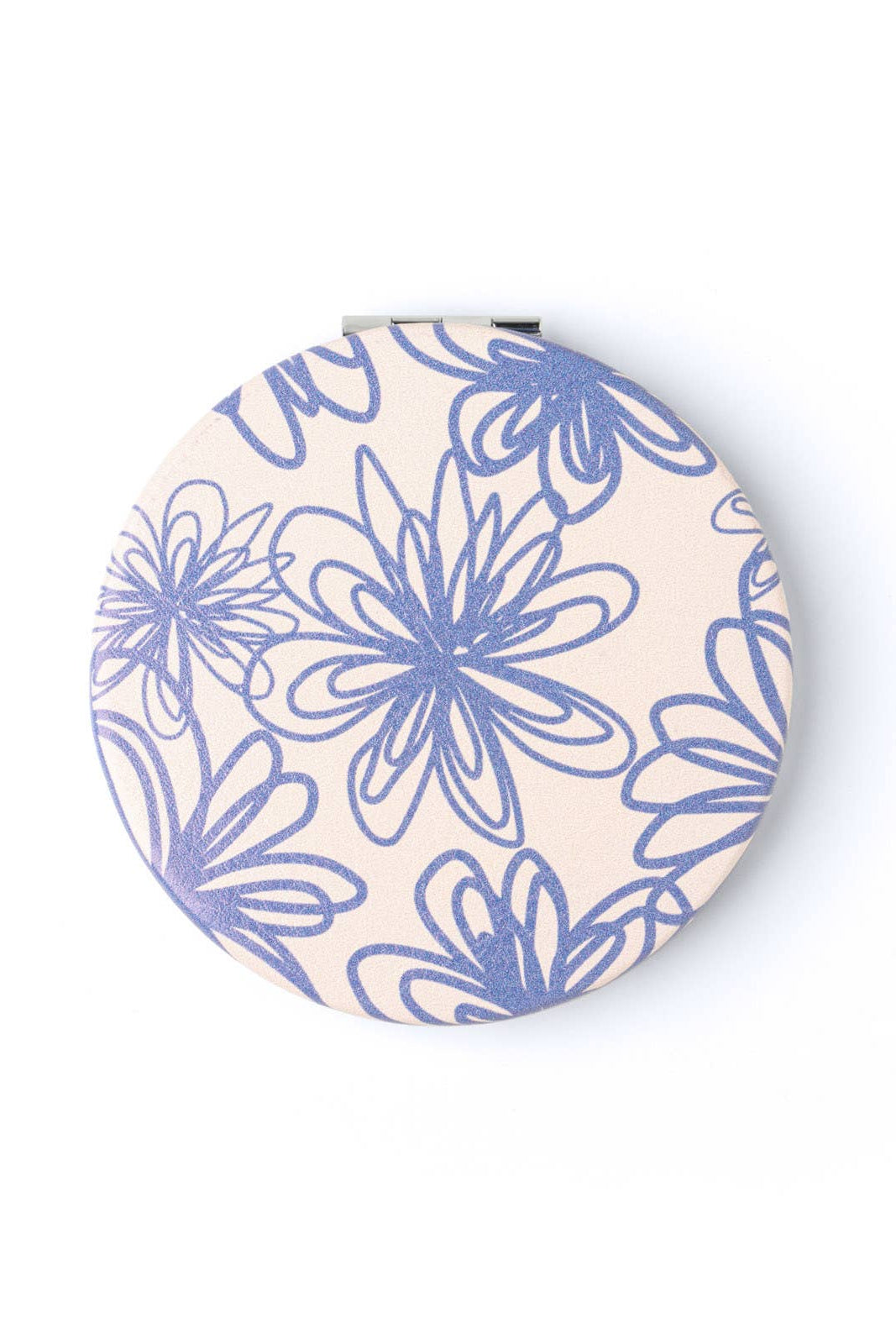Round compact mirror with blue floral pattern on a beige background