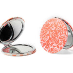 Compact mirror with floral pattern on a white background