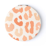 Compact mirror with orange and white leopard print on a white background