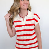 Woman wearing a red and white striped sweater against a plain background