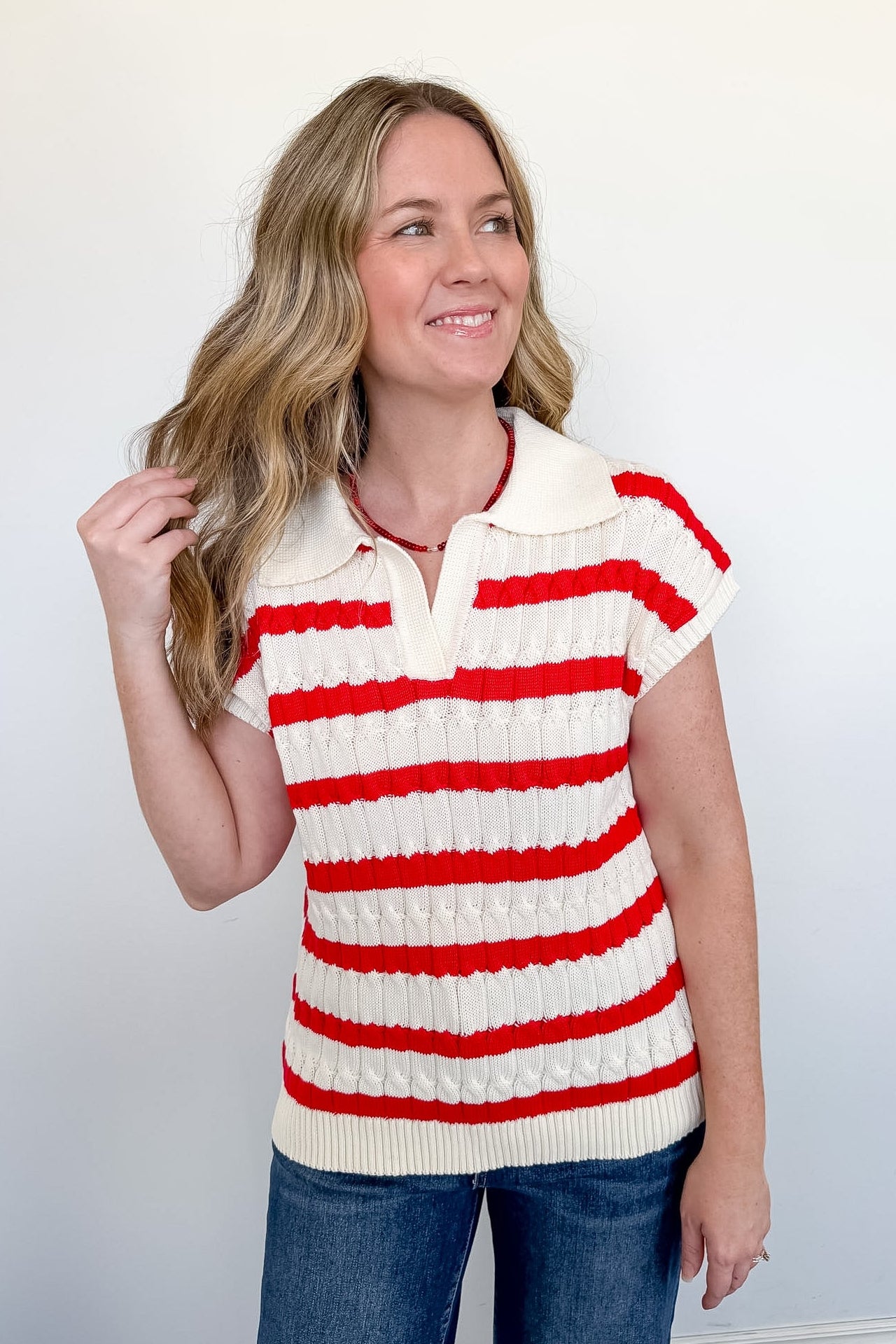 Woman wearing a red and white striped sweater against a plain background