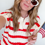 Woman wearing a red and white striped dress with sunglasses, holding an American flag.