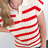 Person wearing a red and white striped shirt with a plain background