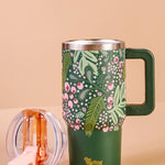Green floral-patterned mug with handle on a beige background