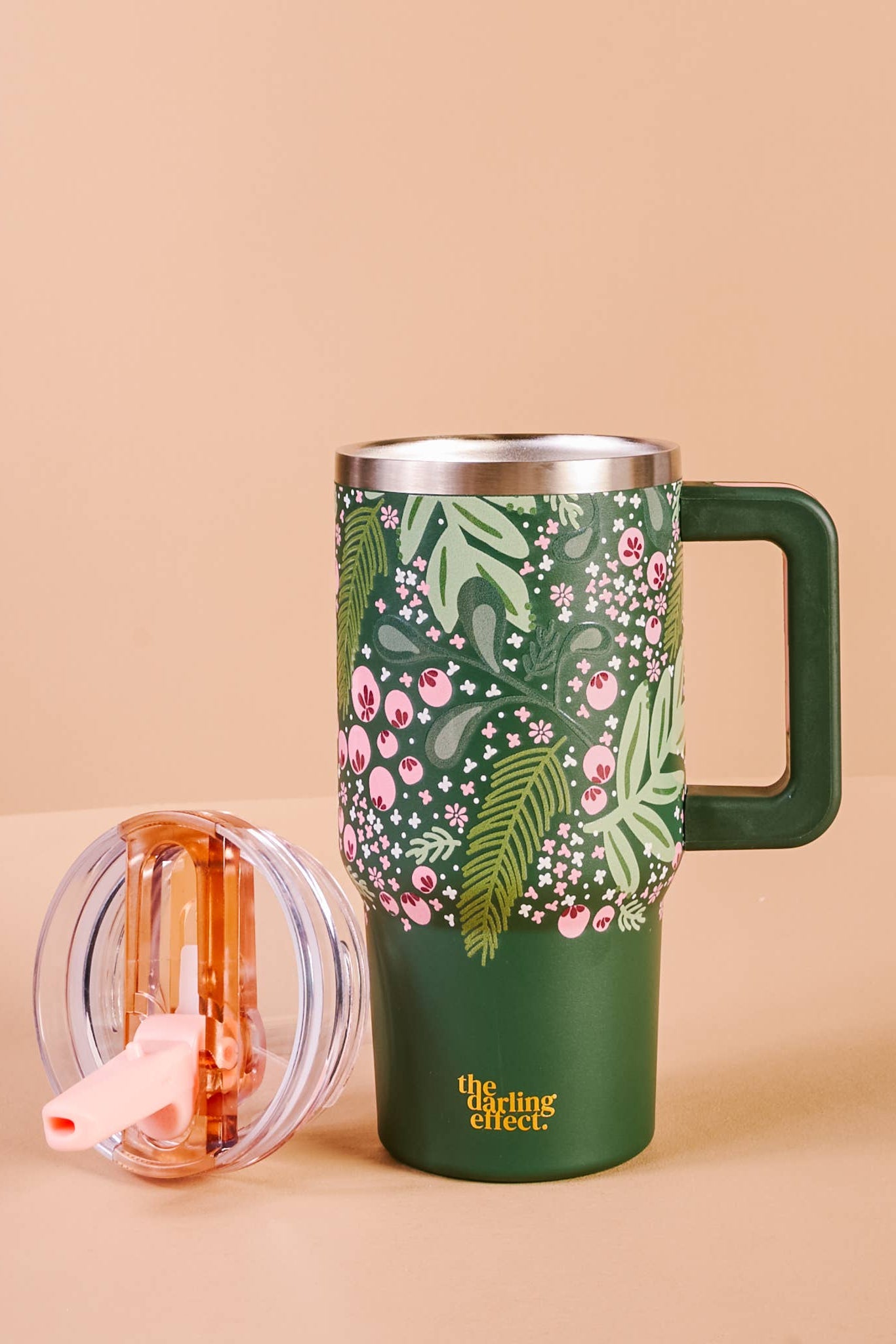 Green floral-patterned mug with handle on a beige background