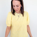 Woman wearing a yellow blouse with a white background