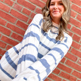 Woman wearing a blue and white striped sweater against a brick wall