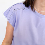 Light purple top with lace details on sleeves against a white background