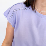 Light purple top with lace details on sleeves against a white background