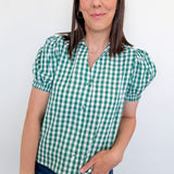 Woman wearing a green and white checkered shirt against a white background