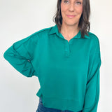 Woman wearing a green sweater against a white background