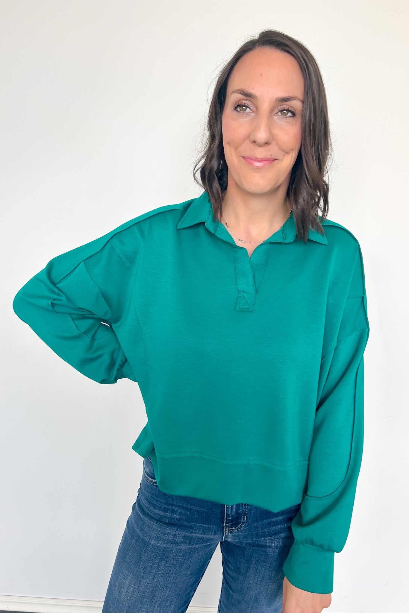 Woman wearing a green sweater against a white background