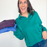 Woman holding a purple garment with blue gloves against a white background