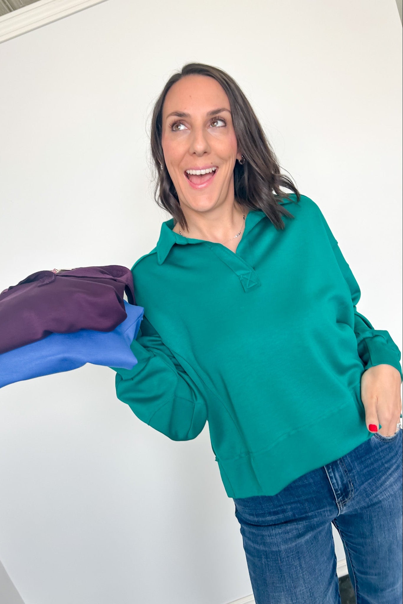 Woman holding a purple garment with blue gloves against a white background