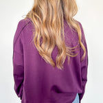 Person wearing a purple jacket and blue jeans on a white background