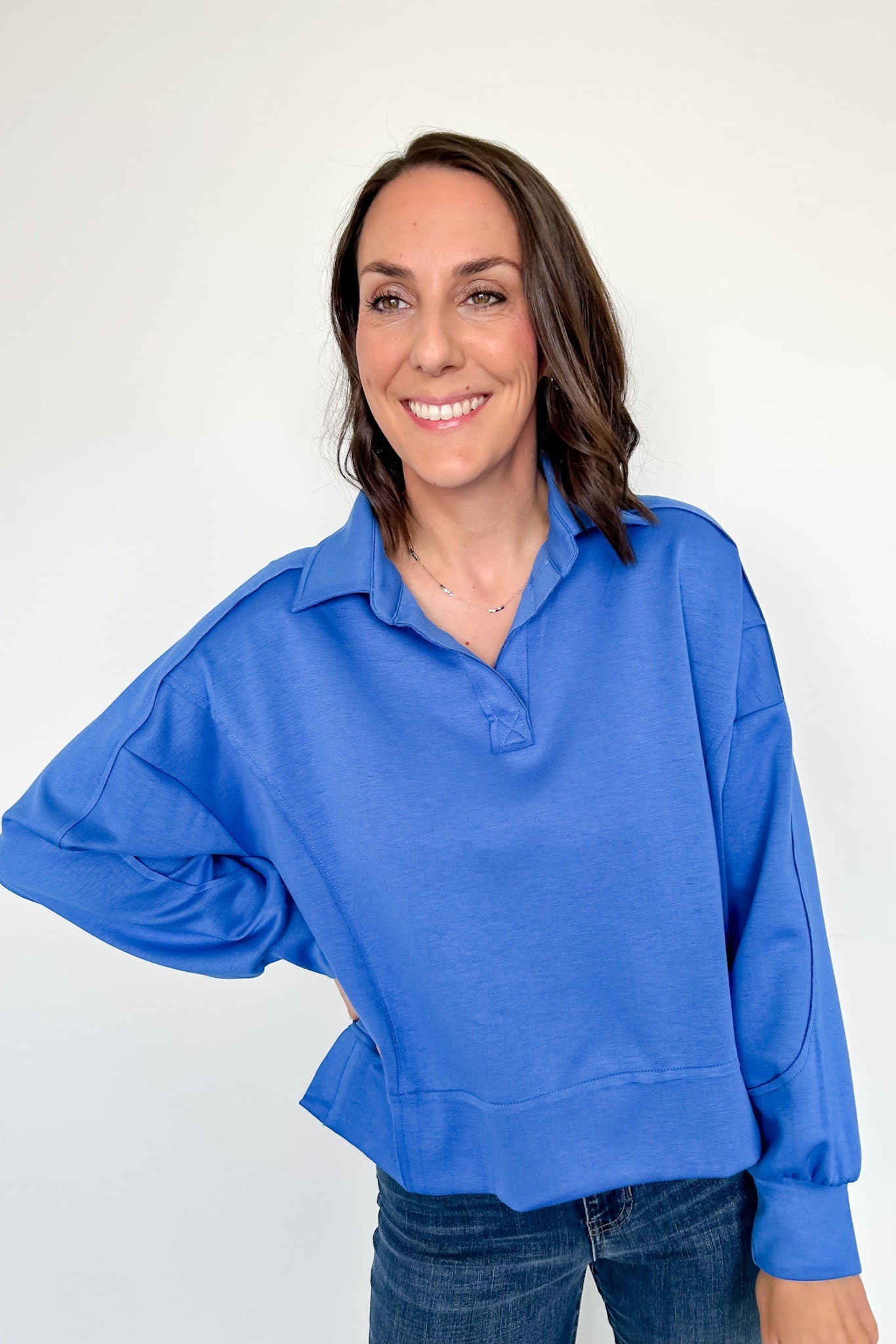 Woman wearing a blue sweater against a white background