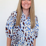 Woman wearing a patterned blouse against a plain background