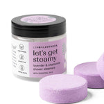 Jar of 'let's get steamy' shower steamers with purple tablets on a white background