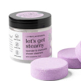 Jar of 'let's get steamy' shower steamers with purple tablets on a white background