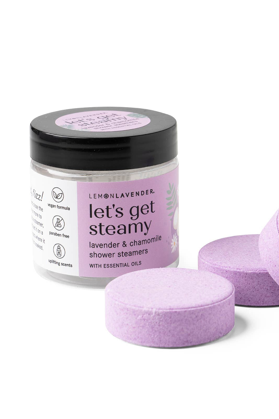 Jar of 'let's get steamy' shower steamers with purple tablets on a white background
