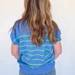 Person wearing a blue and green striped shirt against a white background