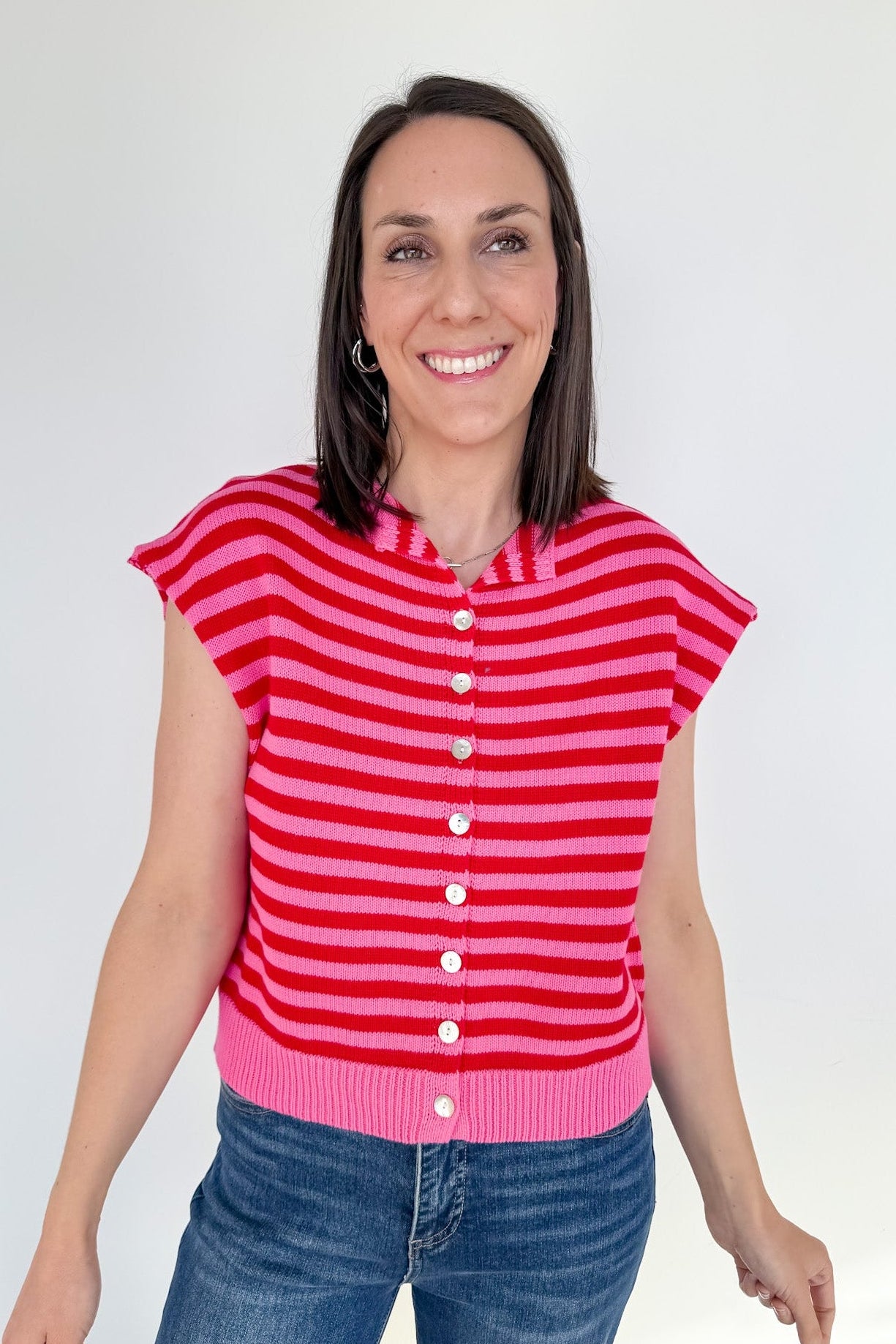 Woman wearing a red and pink striped shirt against a white background