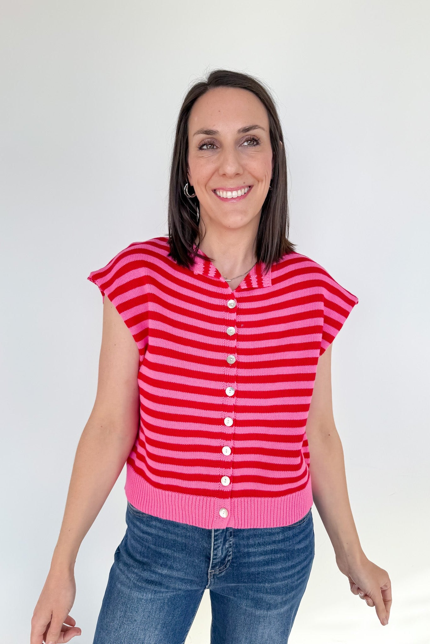 Woman wearing a red and pink striped shirt against a white background