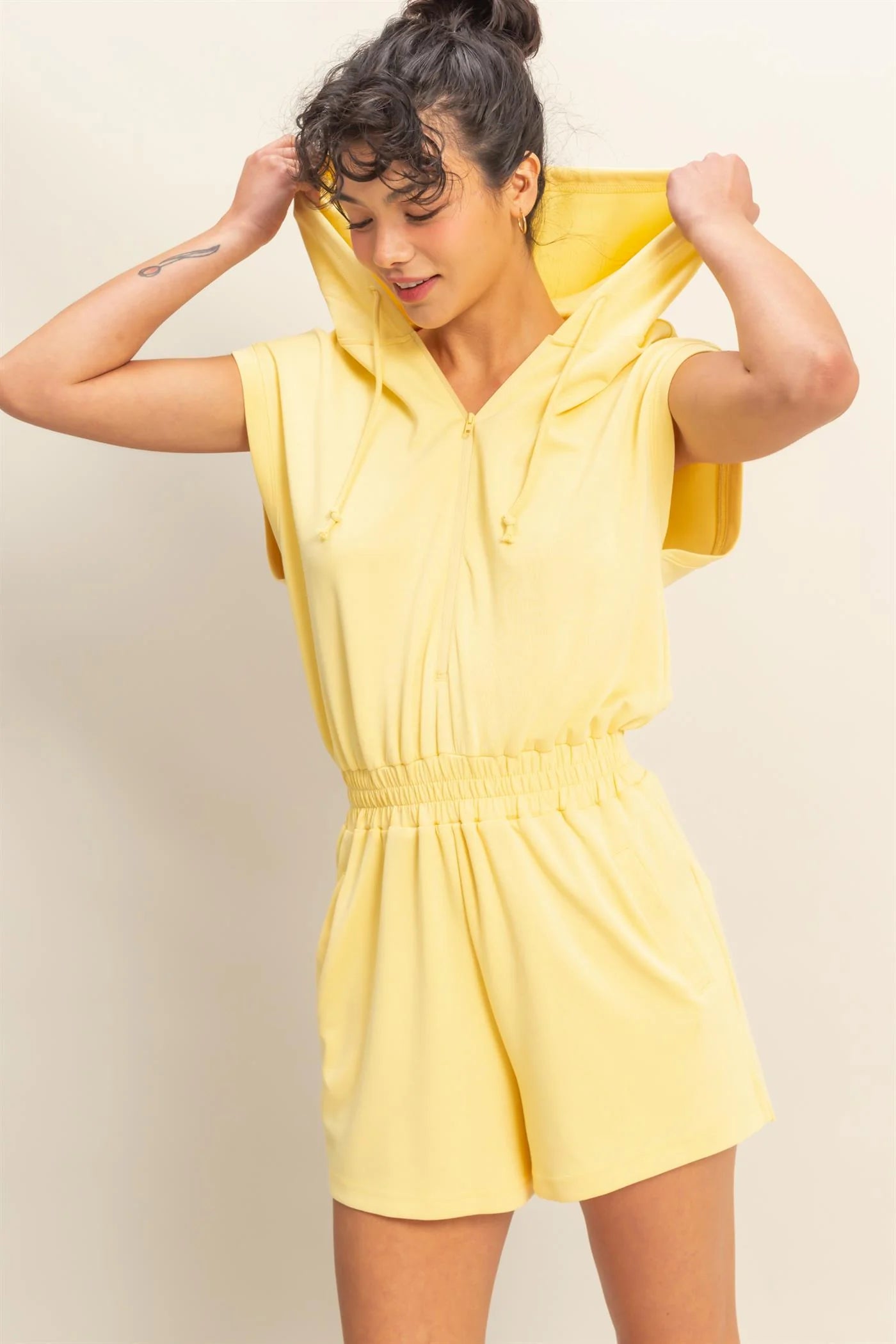 Creamy yellow hooded romper with a functional zipper and pockets. Comfortable and casual look. 