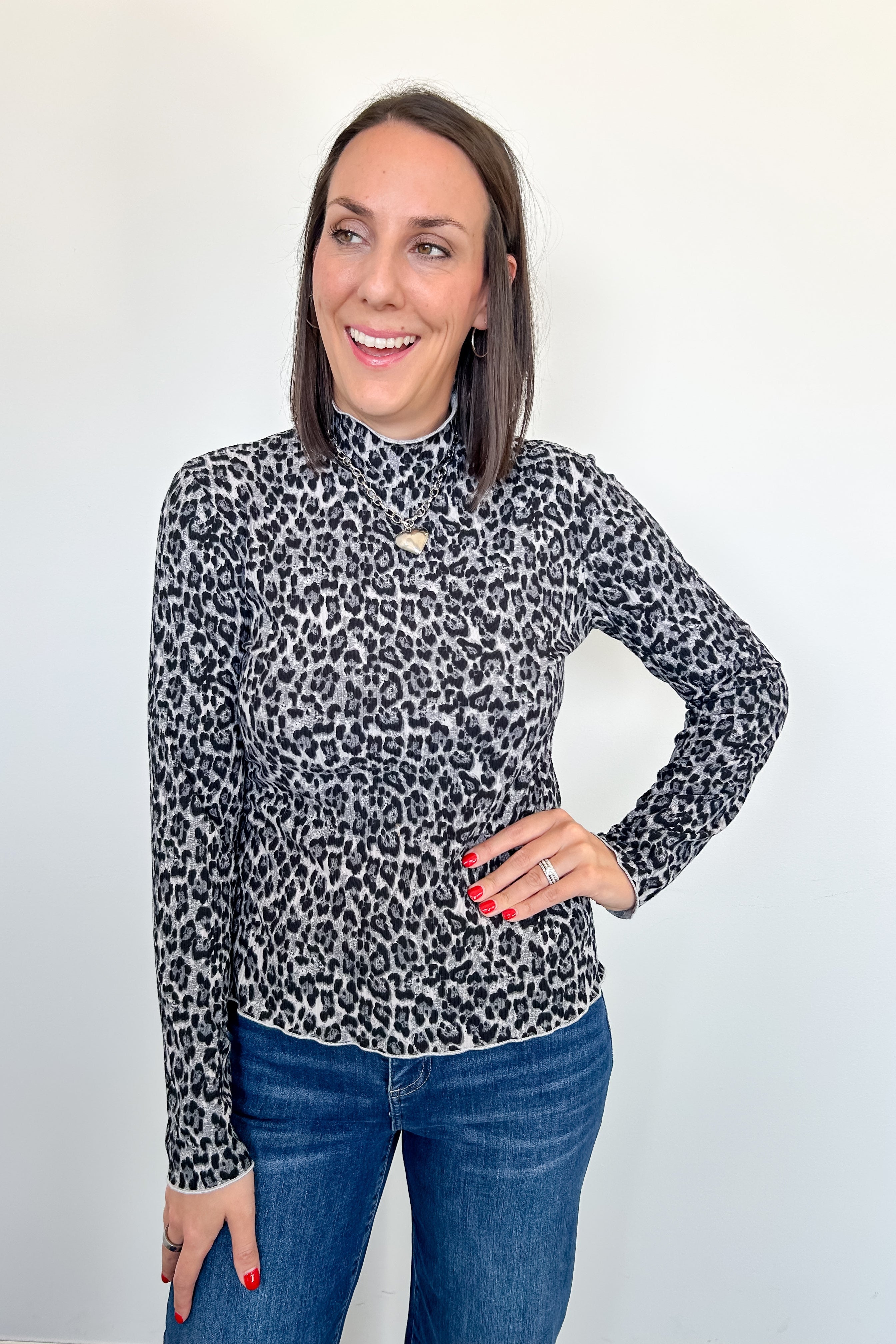 Woman wearing a leopard print long-sleeve top against a white background