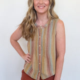 Woman wearing a striped sleeveless top and brown shorts against a white wall
