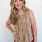 Woman wearing a striped sleeveless top and shorts against a white wall