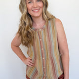 Woman wearing a striped sleeveless top and shorts against a white wall
