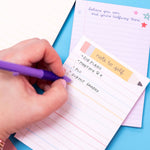 Hand writing on a notepad with a pen on a colorful background