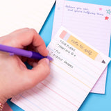 Hand writing on a notepad with a pen on a colorful background